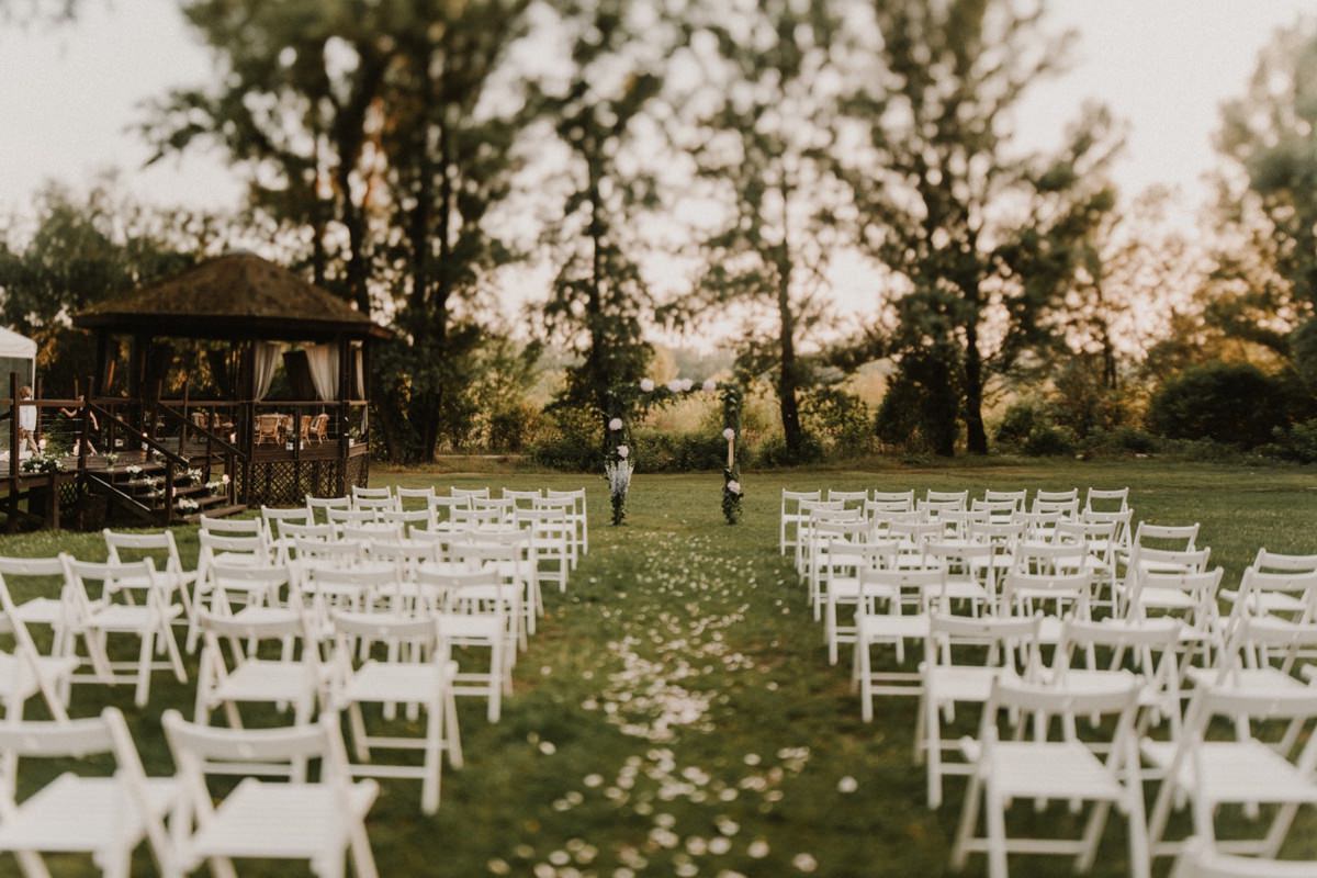 Ślub plenerowy Warszawa - Boathouse białe krzesła pergola z kwiatami ślub przy wiśle